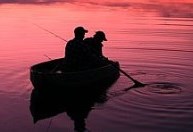 man fishing in boat at sunset