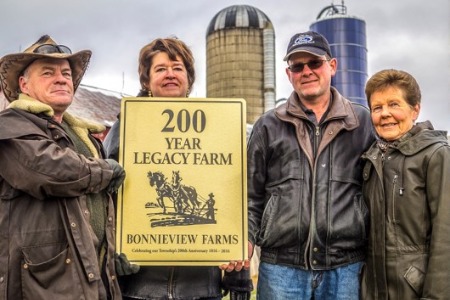 Four people holding a plaque