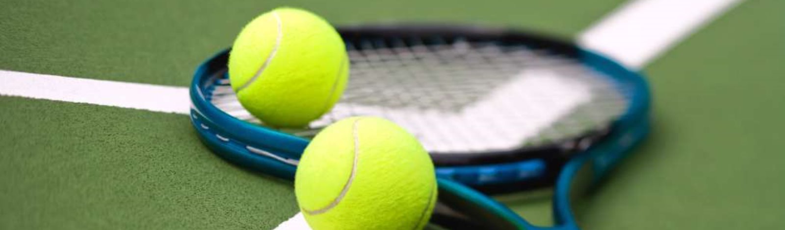 tennis racket and two tennis balls lying on court