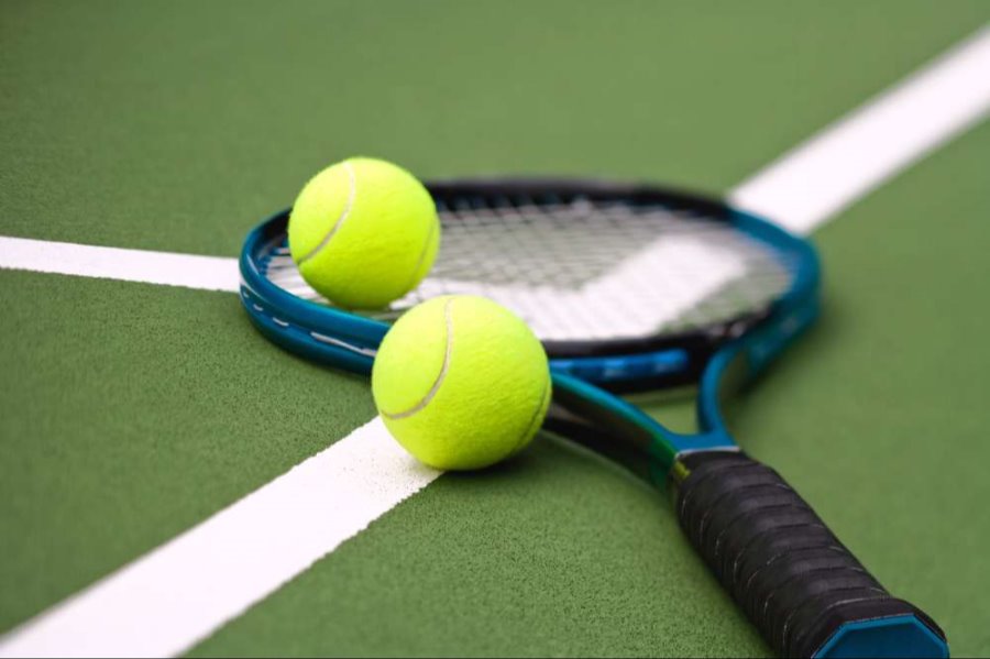 tennis racket a balls laying on a court