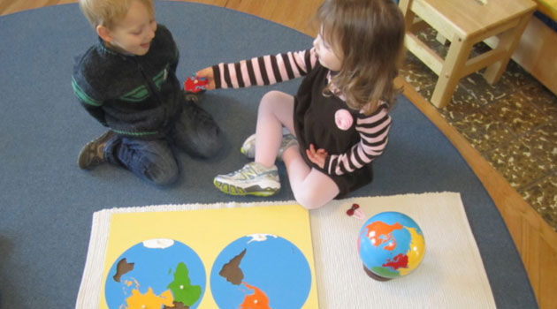 Kids playing with a map of the world