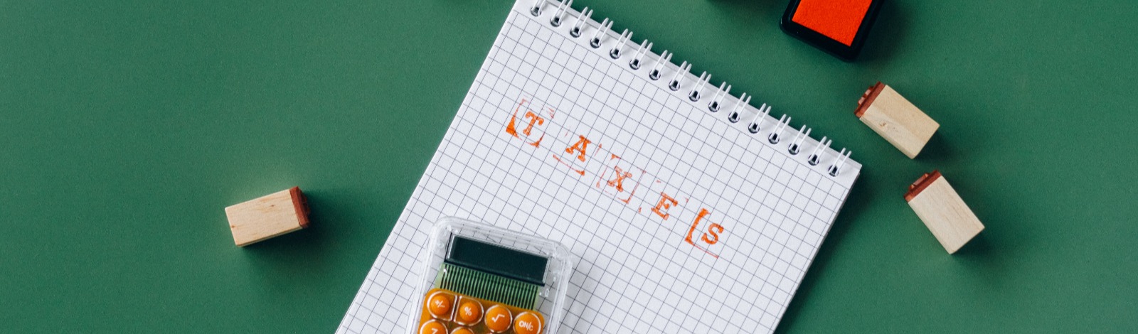 calculator and notepad on green table