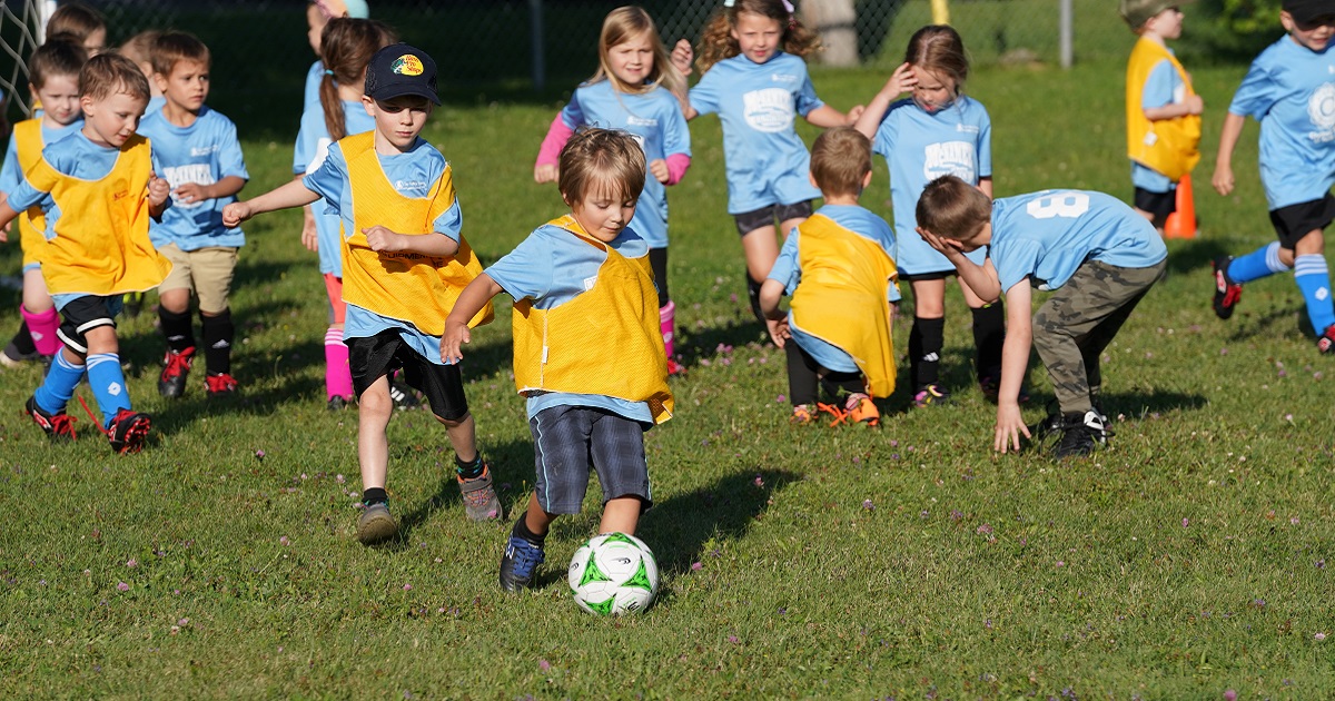 U6 soccer players on field with soccer ball